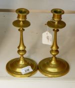 A pair of late Georgian brass candlesticks with knopped stems, on circular bases,