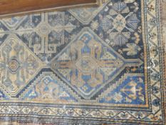An Afghan rug on blue ground, cream borders, geometric pattern,