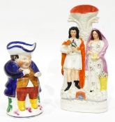 A Staffordshire flatback vase depicting a man holding a bird and woman holding a nest of eggs and