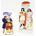 A Staffordshire flatback vase depicting a man holding a bird and woman holding a nest of eggs and