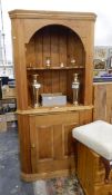 An early 20th century pine corner cupboard with two open shelves, cupboard underneath,