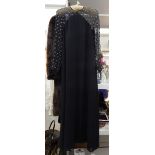 A 1930's full length black crepe evening dress with gauze shoulders and sleeves,