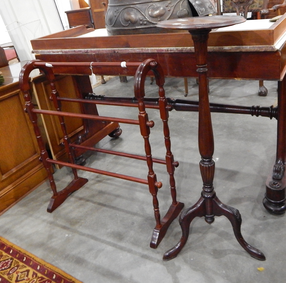 A mahogany torchere raised on turned column and tripod supports and a stained as mahogany towel