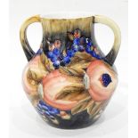 A two-handled vase with tube lined decoration, of pomegranates and berries, in the Moorcroft style,