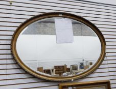 A late Victorian oval wall mirror with bevelled plate and in gilt moulded frame