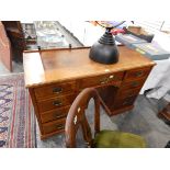 An Edwardian mahogany kneehole pedestal desk having an arrangement of nine drawers,