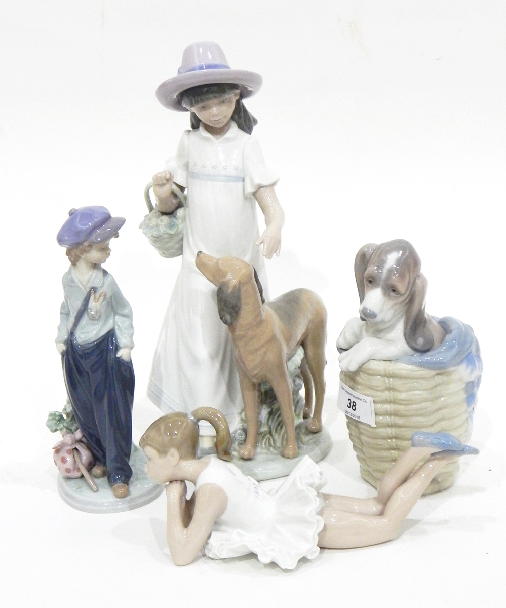 A Lladro model of a Bassett Hound puppy in a basket, a Lladro figure of a young boy,