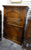 An oak reproduction cocktail cabinet with floral pattern to edge