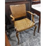 A cane panelled beech framed elbow chair on cabriole supports