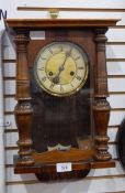 A stained wood wall clock with turned fore-pilasters and a Victorian marble and black slate mantel