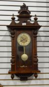 A stained walnut Vienna regulator style wall clock having ornate, foliate and floral pediment,