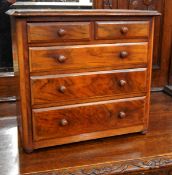 A late Victorian walnut miniature chest with moulded edge top, two short and three long drawers,