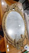 A Victorian oval bevelled plate wall mirror within a gilt moulded frame and having three candle