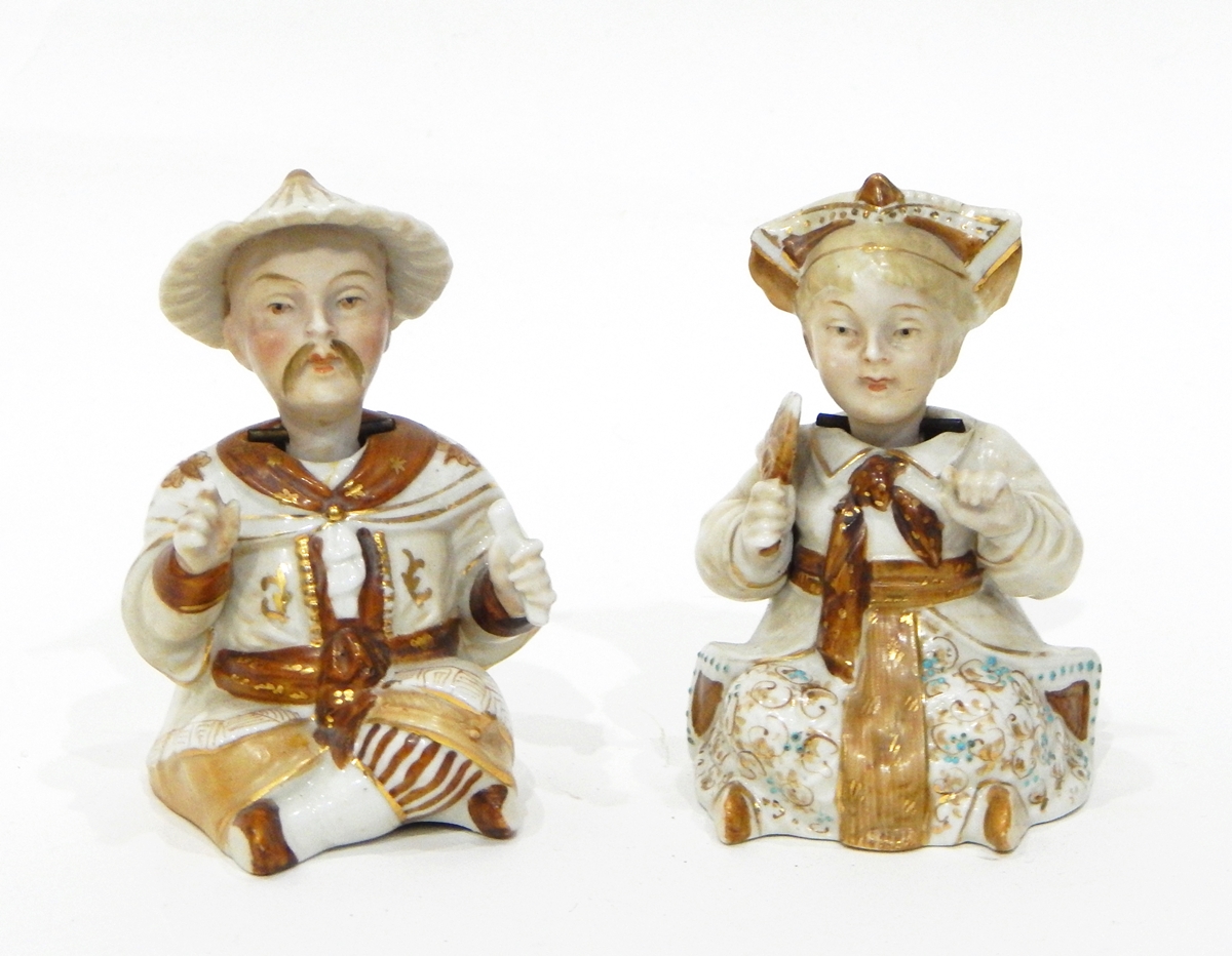 A pair of Victorian nodding head figures modelled as a seated man and a seated woman in Oriental
