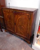 A early nineteenth century mahogany side cupboard, the pair of panelled doors,