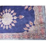 A Persian style wool rug having blue ground and red borders, floral and geometric pattern,