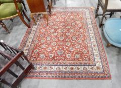 A Persian style rug with red ground and cream borders, floral decoration,