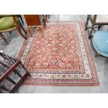 A Persian style rug with red ground and cream borders, floral decoration,