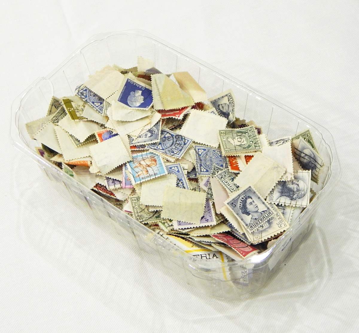 A quantity of loose postage stamps of various nations together with a Chad Valley tin coin box with