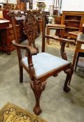 A walnut Chippendale style open armchair with heavily carved crest rail and pierced splats,