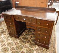 An oak kneehole desk with eight flanking drawers, single long frieze drawer to centre,