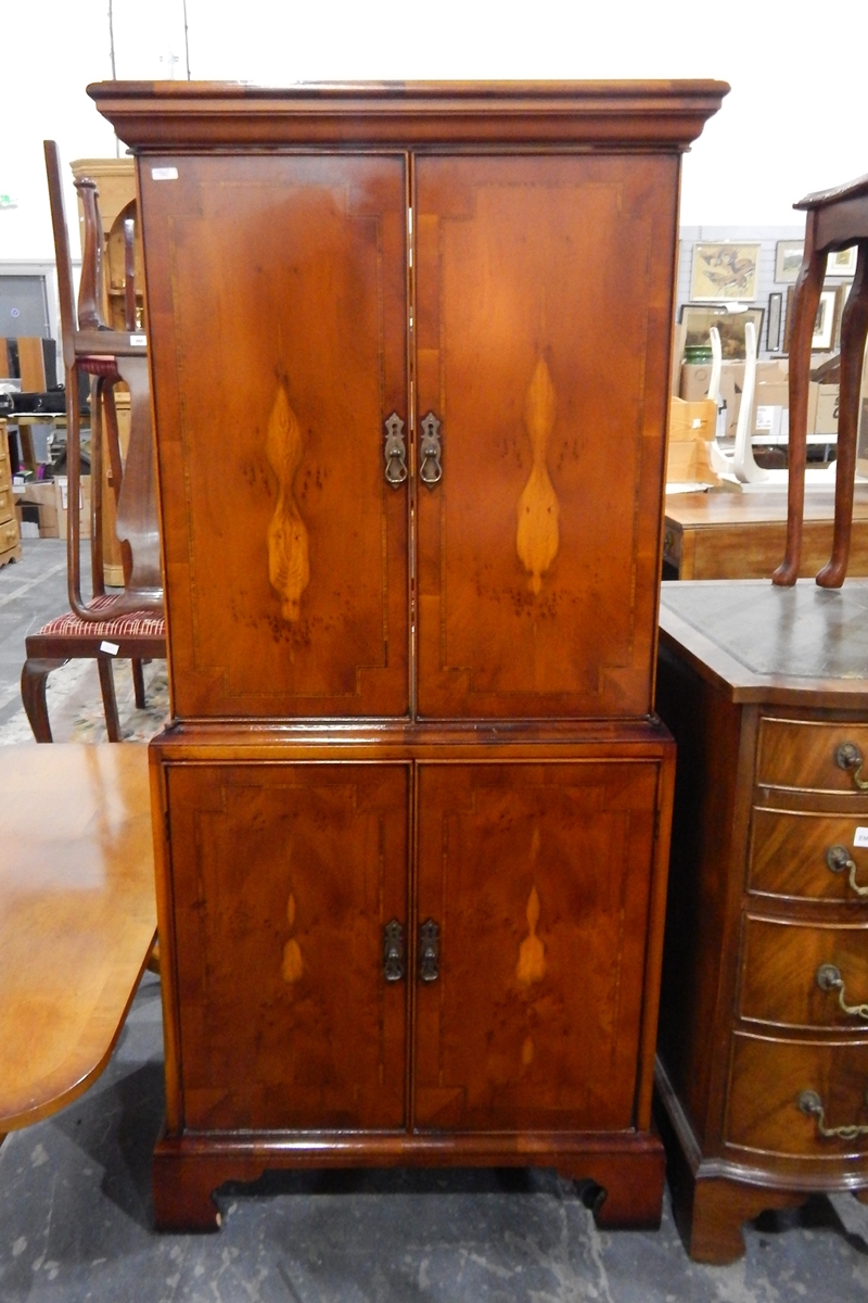 A yew veneered cabinet and a similar cross-banded coffee/magazine table (2)