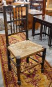 A set of four rush seated spindle back oak dining chairs and a rush seated elbow chair (5)