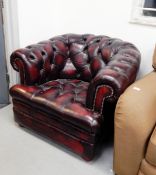 A burgundy leather Chesterfield three seat sofa with button back decoration and matching armchair