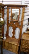A pine hall stand with mirror-backed and shaped splats, box seat, brass hooks,