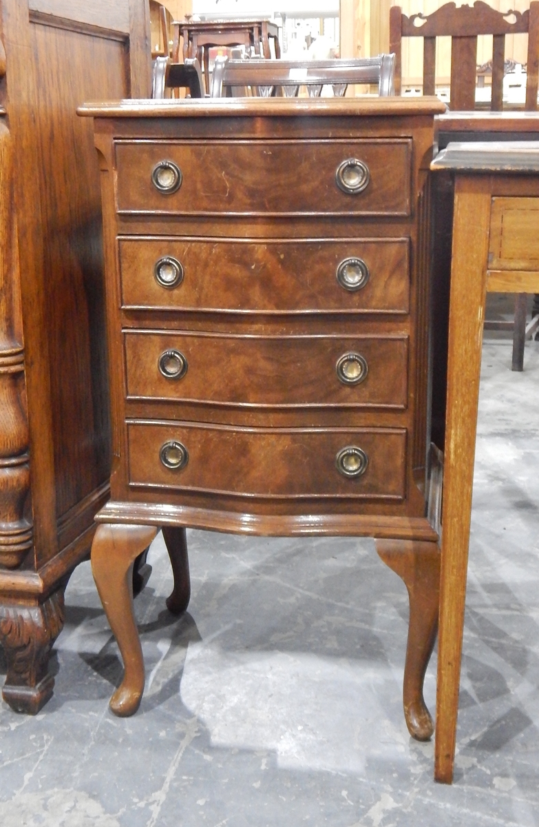 A late 20th century serpentine-fronted bedside chest of four drawers and on cabriole supports,