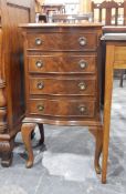 A late 20th century serpentine-fronted bedside chest of four drawers and on cabriole supports,