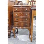 A late 20th century serpentine-fronted bedside chest of four drawers and on cabriole supports,