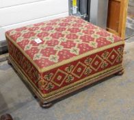 A Victorian footstool with lattice pattern woolwork tapestry, on bun feet,
