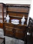 A reproduction oak dresser with plate rack, two short drawers and cupboard underneath,