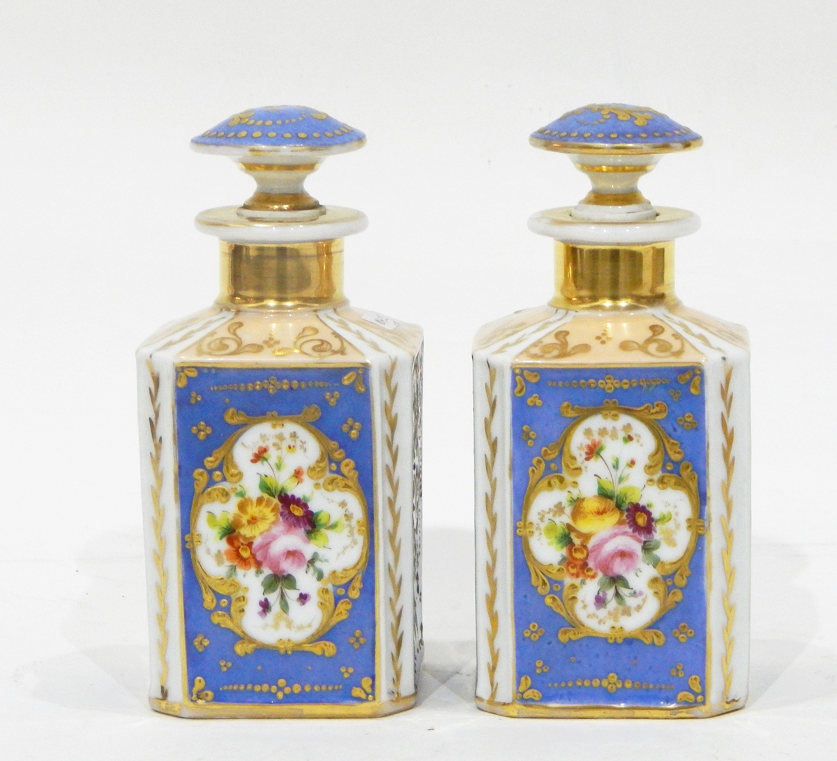 A pair of continental porcelain scent flasks and stoppers of square form,