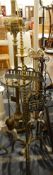 A brass fire companion with two candle holders, the fire irons hanging from a frame,