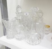 A glass decanter of circular form with thumb cut decoration, a cut glass decanter of square form,