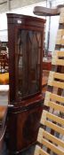 A mahogany veneered corner cabinet with glazed front and astragal decoration,