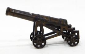 A miniature bronze model of a cannon with integral wheeled base,