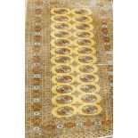 A small rug, the centre with medallion design, in brown and cream, on fawn centre field,