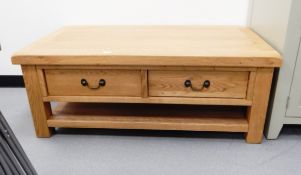 A modern oak coffee table with four short drawers, loop brass handles,