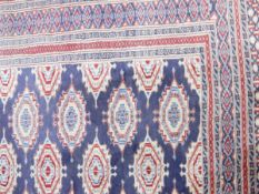 A Persian style rug with blue ground, red and blue borders, geometric pattern,