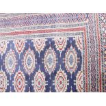 A Persian style rug with blue ground, red and blue borders, geometric pattern,