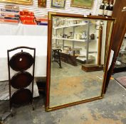 A wooden framed rectangular wall mirror with brass corners, the bevelled plate 114 x 83cm,