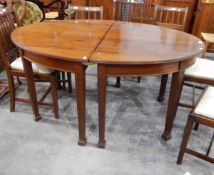 An oval mahogany dining table with reeded supports (lacking insert leaves)