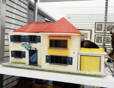 A 20th century doll's house with red roof and garage,