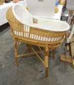 A wicker child's crib on stand