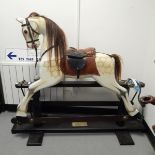 A limited edition painted wooden rocking horse, the horse with leather saddle,