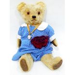 A vintage mohair bear with glass eyes with a fob watch attached
