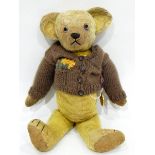 A vintage mohair teddy with glass eyes with a 1902 coronation medal pinned to him